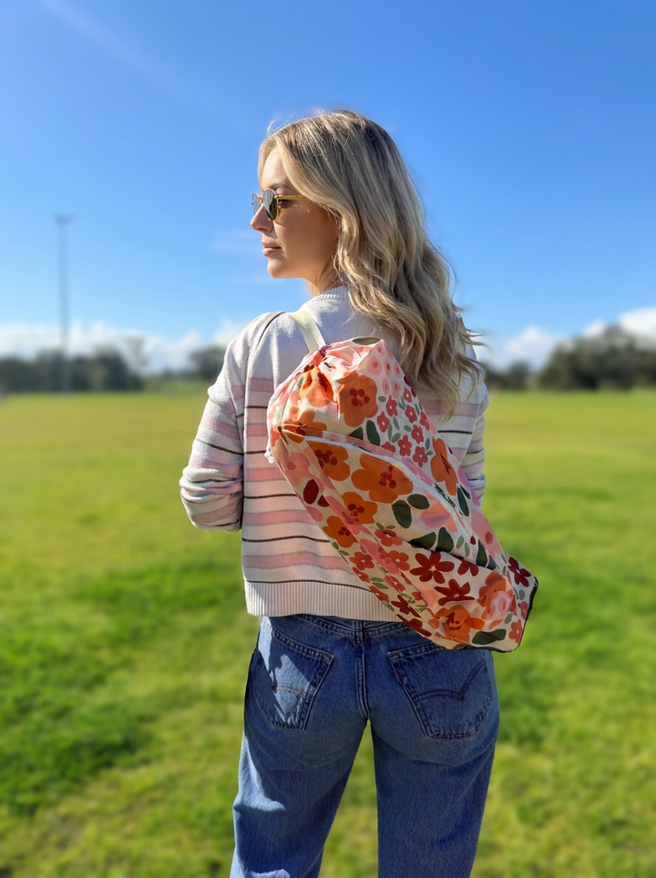 mum carries the river floral campie chair over her shoulder in the bag for easy transport