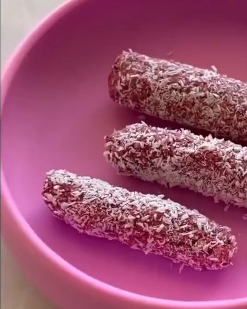 Raspberry coconut bars for babies in a pink suction bowl