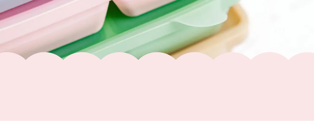 Close-up of a pink and green container with a white lid on a white background