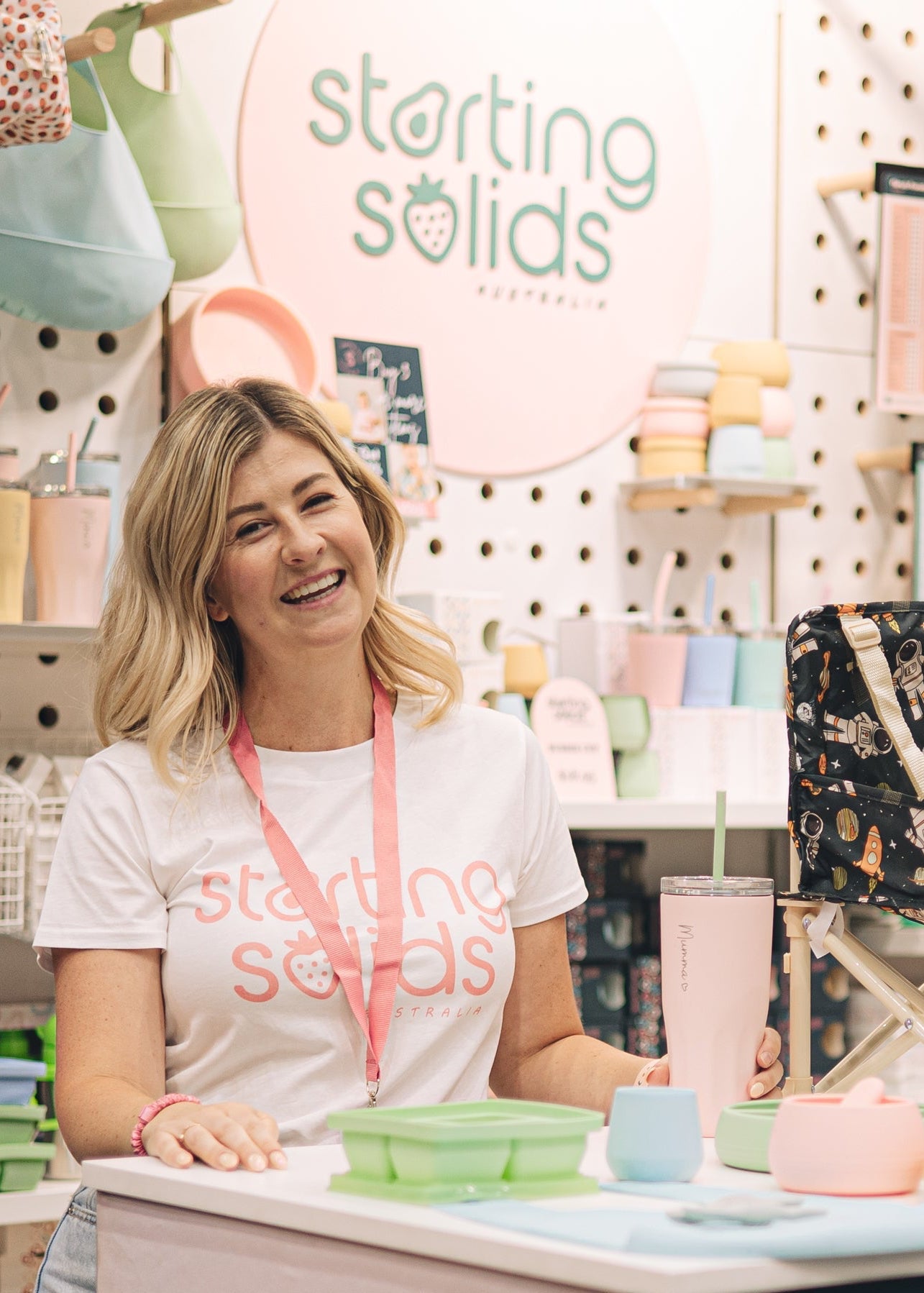 Person working at a Starting Solids booth in a store with products and branding visible.