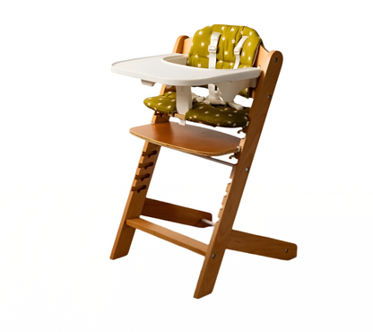 Wooden high chair with green cushion on a wooden floor