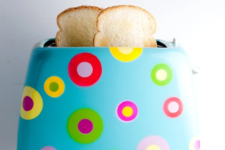 White toast popping out of a colourful toaster.