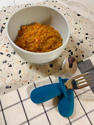 Creamy Indian Dahl in a bowl with Toddler Silvies by Starting Solids Australia on a bench.