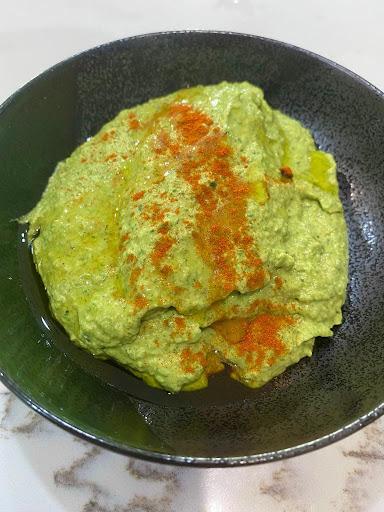 Iron rich hummus and spinach dip in a black bowl by Starting Solids Australia