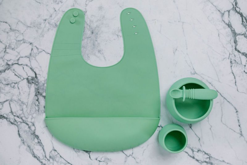 Green (Mint Crisp) silicone bib, cup, bowl and spoon set for babies on a marble bench by Starting Solids Australia