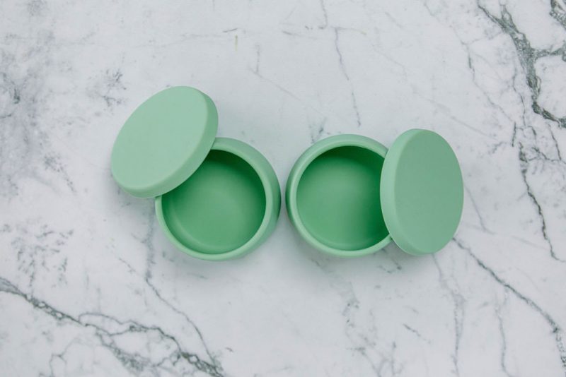 Birdseye view of Suckie Scoop Mini Bowls with lids in 'Mint Crisp' green on a marble bench.