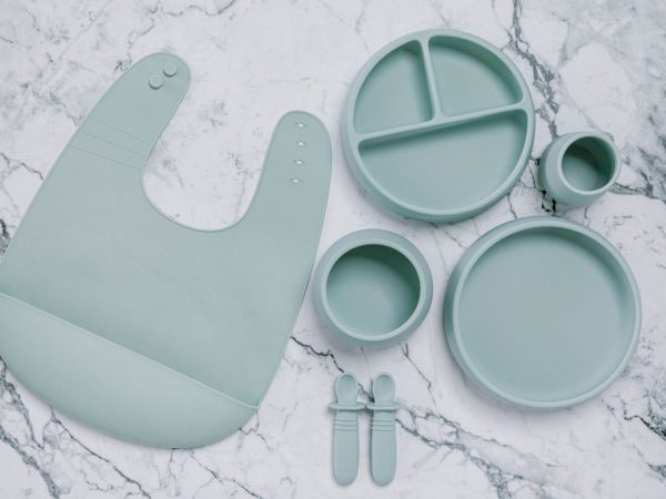 Grey silicone bib, Bubbie Cup, Suckie Scoop Divided Plate, Suckie Scoop Plate, Suckie Scoop Bowl and Selfie Spoon set for babies by Starting Solids Australia, on a marble bench.