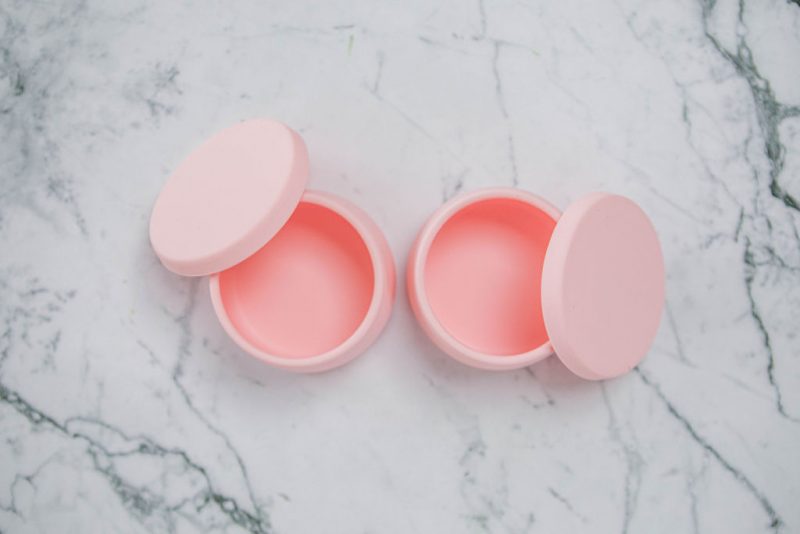 Birdseye view of Suckie Scoop Mini Bowls with lids in 'Fairy Floss' pink on a marble bench.