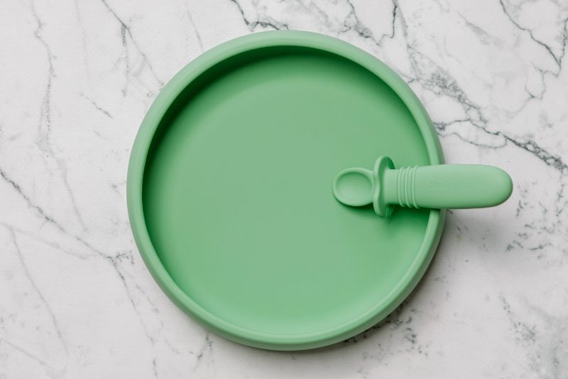 Green Suckie Scoop Plate with Selfie Spoon by Starting Solids Australia, on a marble bench.