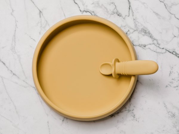 Yellow Suckie Scoop Plate with Selfie Spoon by Starting Solids Australia, on a marble bench.