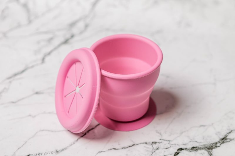Pink silicone Snackie Cup for babies by Starting Solids Australia on a marble bench.