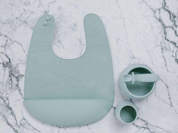 Blue (Meringue) silicone bib, cup, bowl and spoon set for babies on a marble bench by Starting Solids Australia