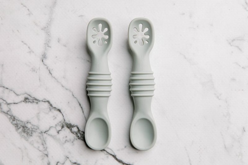 Grey silicone sticky spoons for baby on a marble bench by Starting Solids Australia
