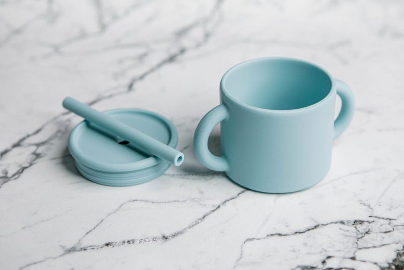 Ideal First Baby Cup in 'Blue Lemonade' colour by Starting Solids Australia, in parts, on a marble bench.