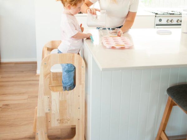 Toddler in kitchen using Starting Solids Australia's Toddler Tower